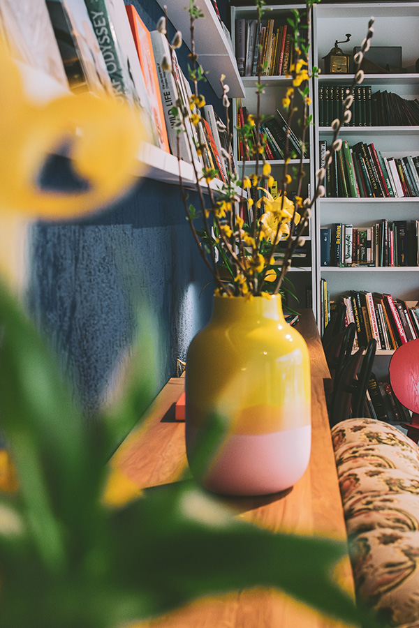 Blumenvase mit Bücherregal im Hintergrund